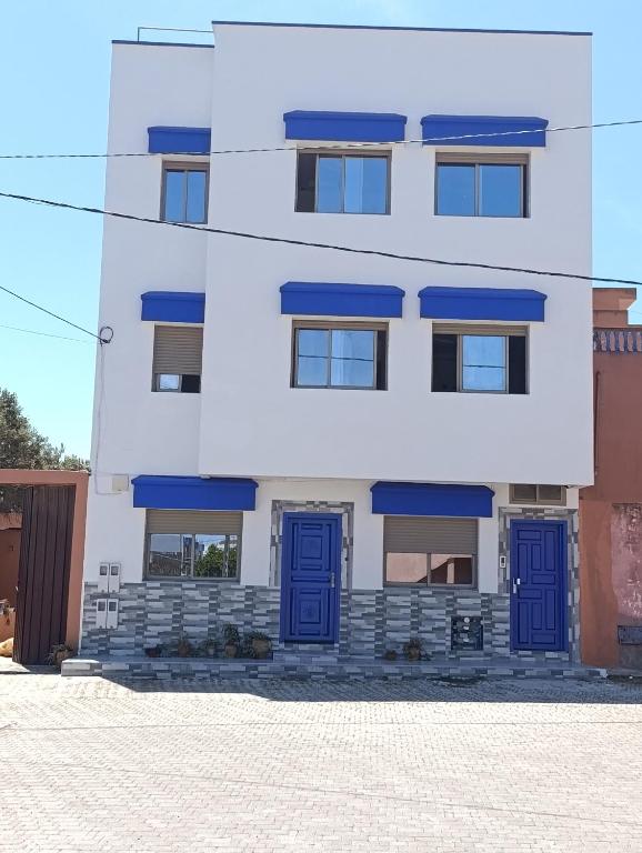 a building with blue doors in front of it at Appartements Hajar in Oualidia