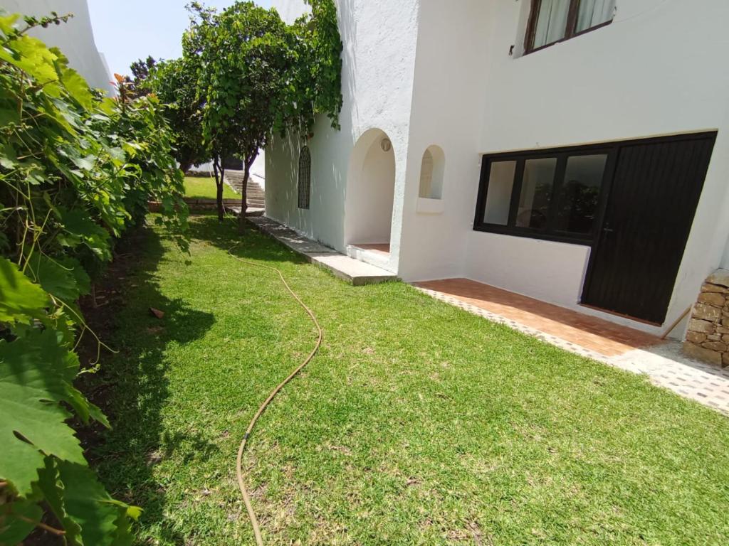 a yard with a hose in front of a house at Maison de plage familiale à Cabo in Cabo Negro