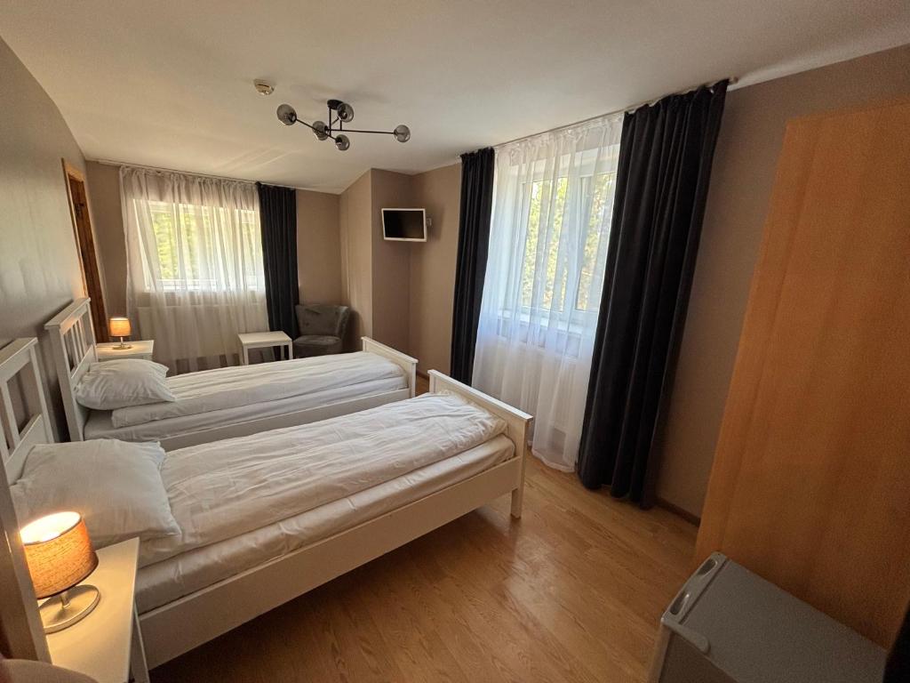 a hotel room with two beds and a window at Pas Kastyti in Palanga