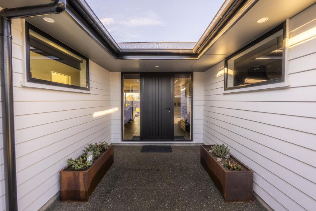 a home entrance with white siding and windows at Stay at 2A in Twizel
