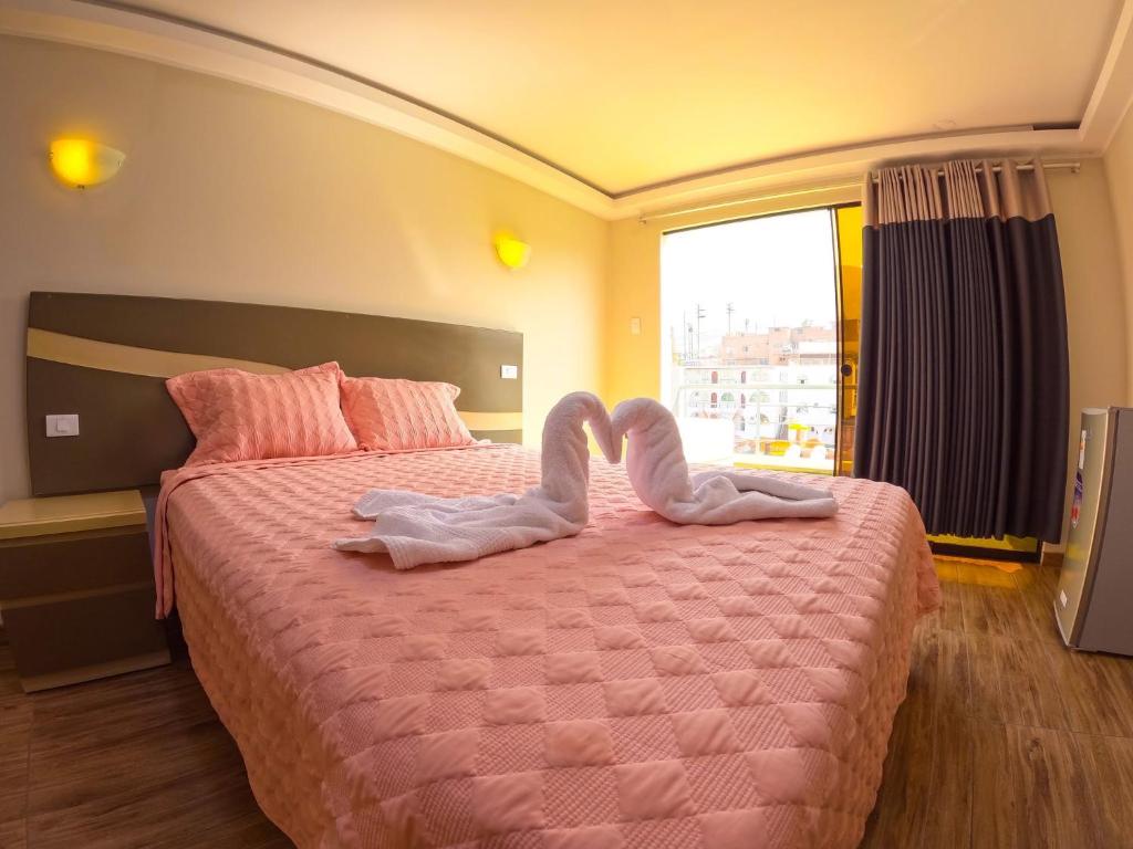 a bedroom with a bed with two mitts on it at Colpeña Chinchana in Chosica