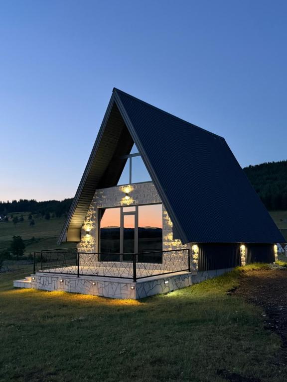 a cabin with a black roof with lights on it at V Chalet in Žabljak