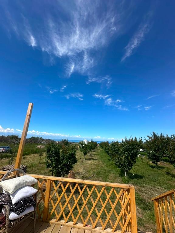 a wooden deck with a view of a field at Nomads Home in Tong