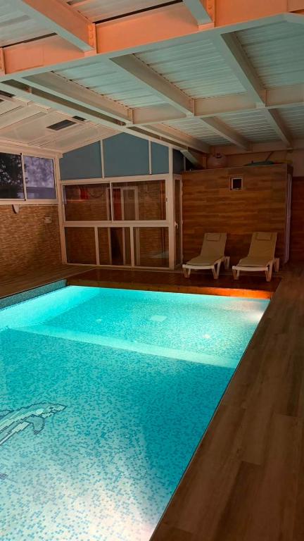 a large swimming pool with blue water in a room at Nouira Haus in Akouda