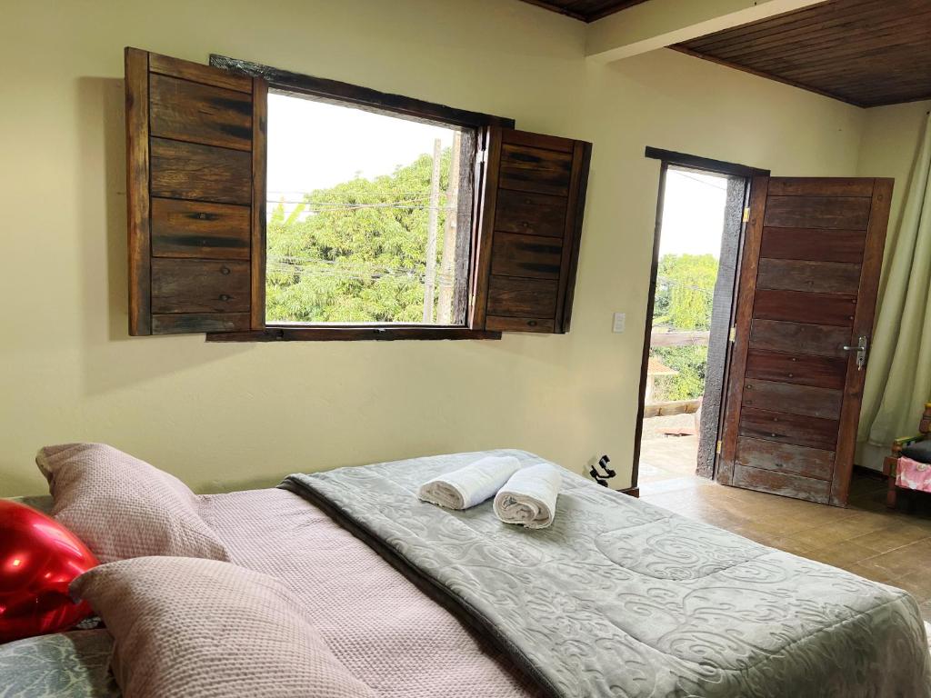 a bedroom with a bed with two towels on it at Chalés do Chá in Lavras Novas