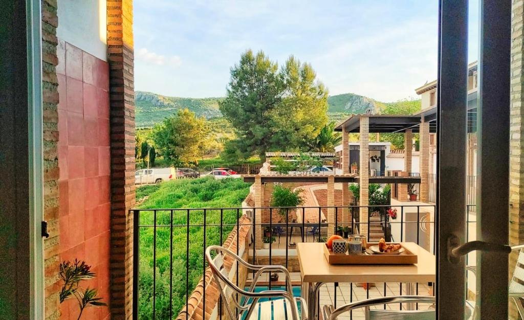 a balcony with a table and chairs and a view at El Pajar - Apartamento rural en la Vía Verde in Luque