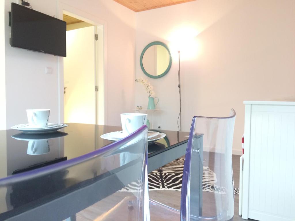 a dining room with a glass table and a mirror at Golden Halcyon - Ericeira Villas in Ericeira