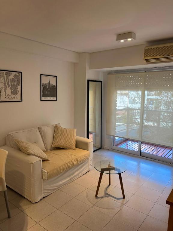 a living room with a couch and a table at Torre Parque Apartamento in Morón