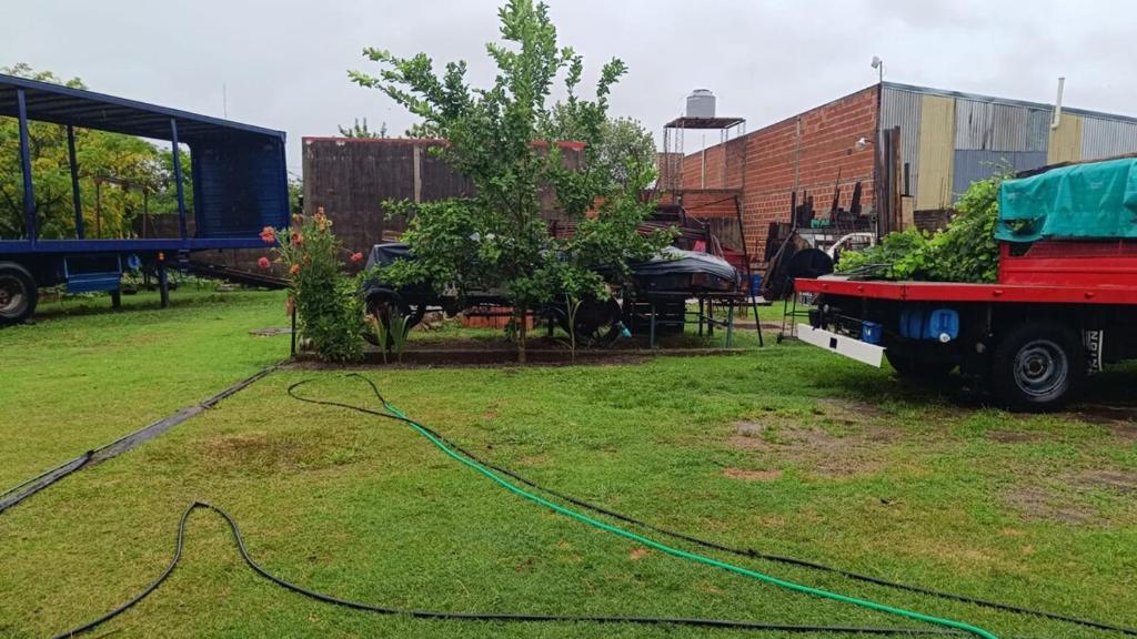 a truck with a hose on the grass in a yard at La Ricarda in Gualeguaychú