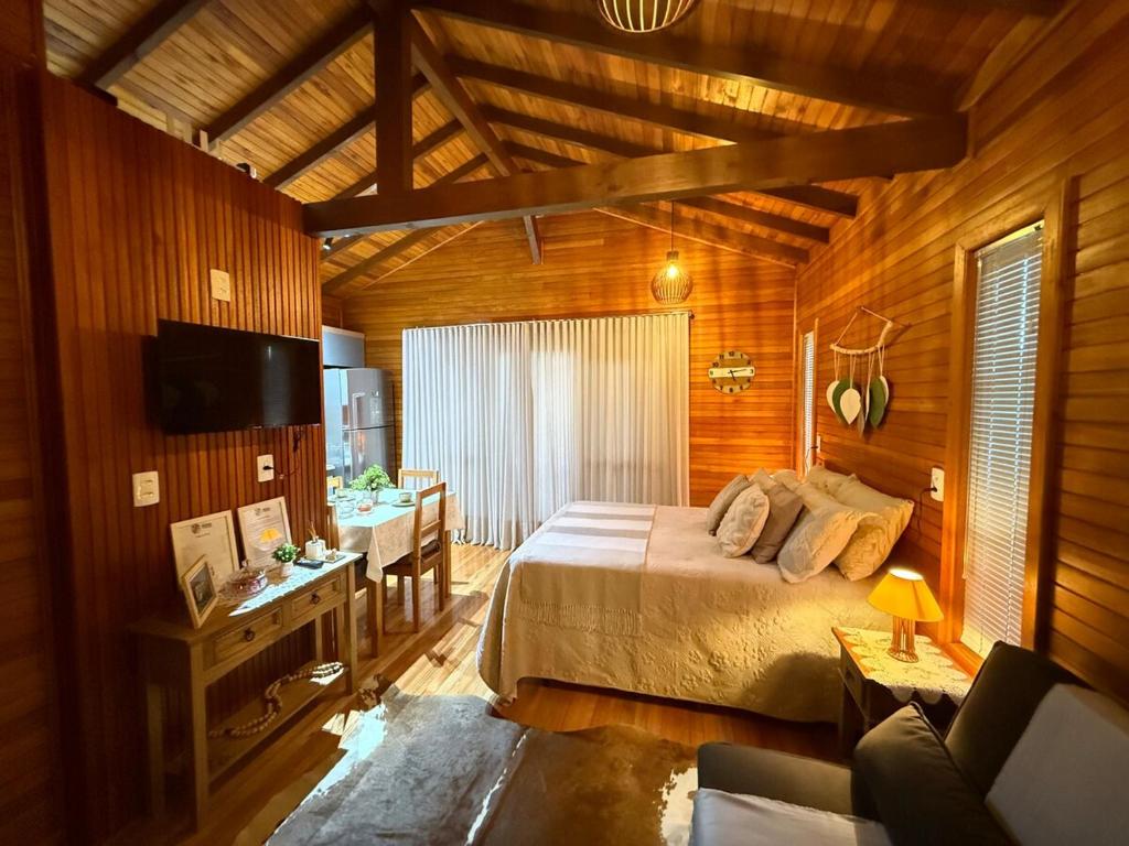 a bedroom with a bed and a desk and a television at Sítio Brisa da Serra Conforto e Tranquilidade in Lauro Müller