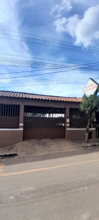 a building with a fence on the side of a street at Hotel Reflexos in Santa Juliana