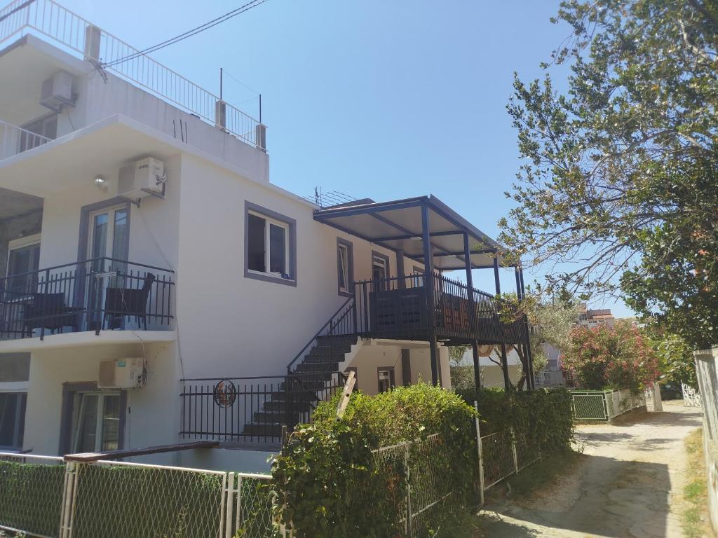 a white building with stairs and a balcony at Pejovic Guest House in Sutomore