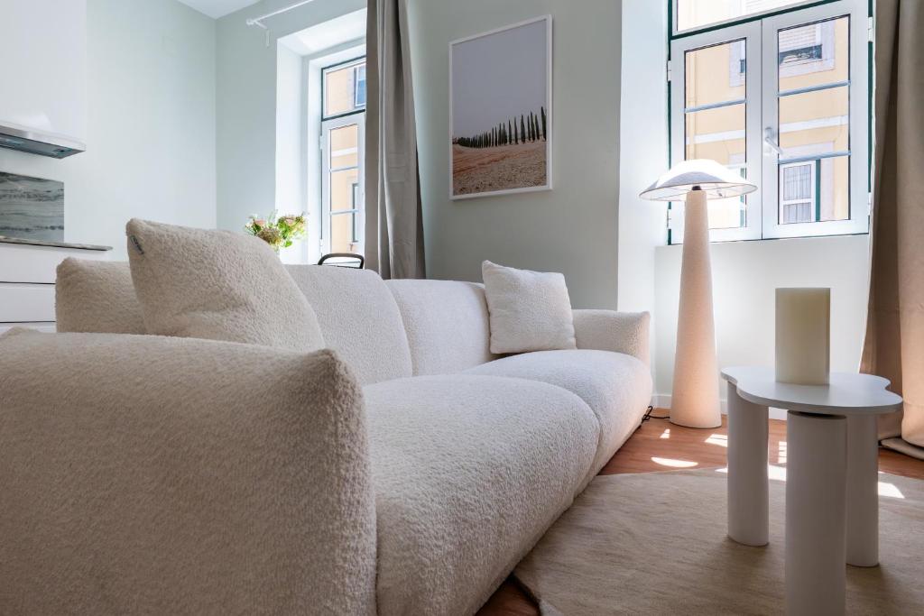 a living room with a white couch and a table at Flores 21 Apartments Príncipe Real in Bicas