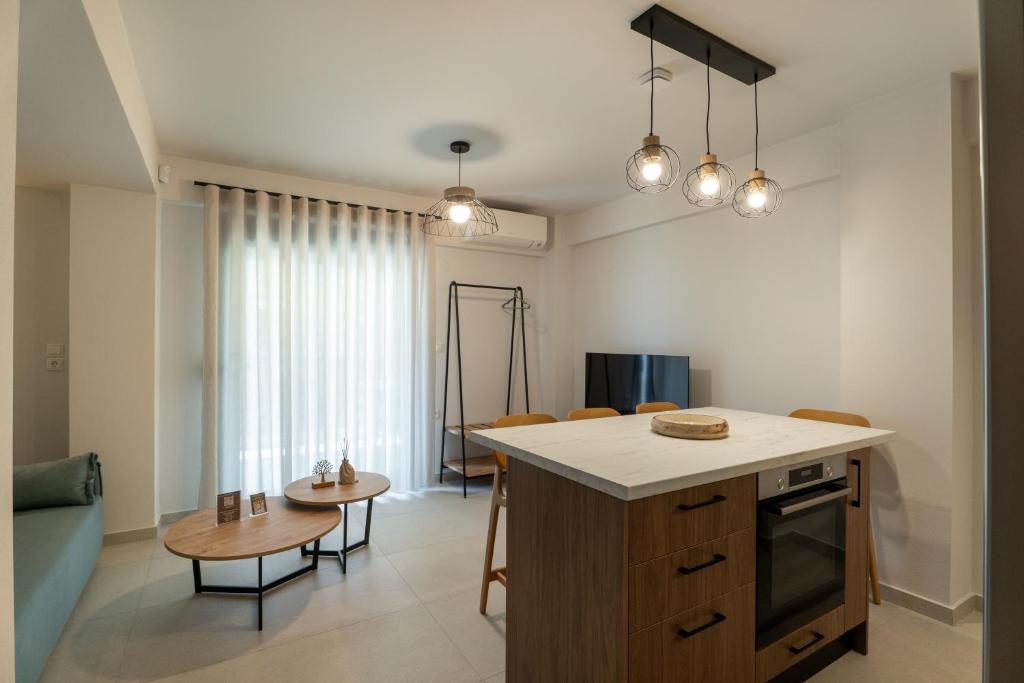 a kitchen and living room with a table and chairs at AKSQUARED Premium Vacation Apartments in Paralia Dionysiou