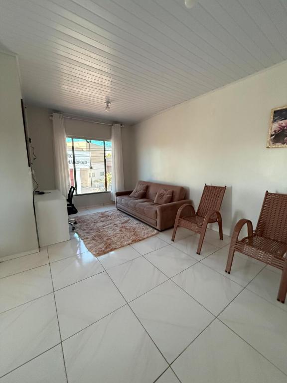 a living room with a couch and two chairs at Apt Serras Gerais Superior in Dianópolis