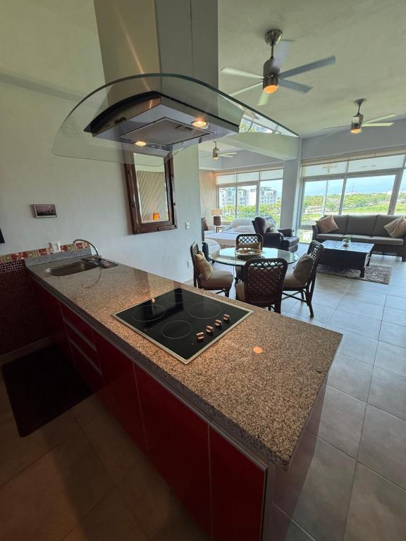 a kitchen with a stove and a living room at departamento 314 in Nuevo Nayarit