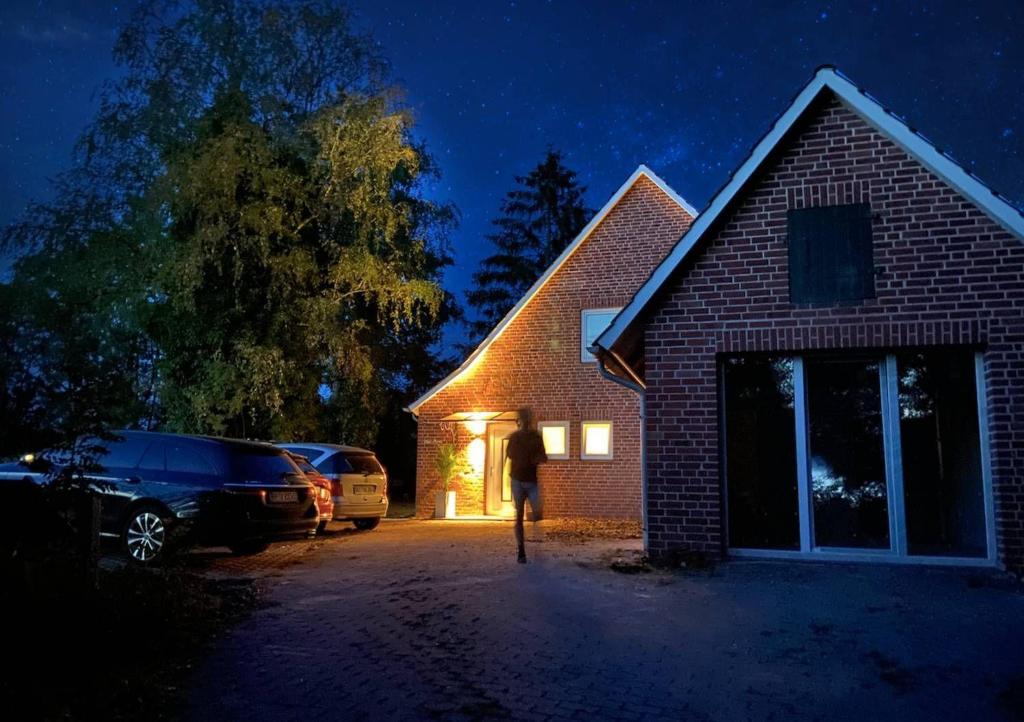 a person standing outside of a house at night at AHOI-MARIE in Blekendorf