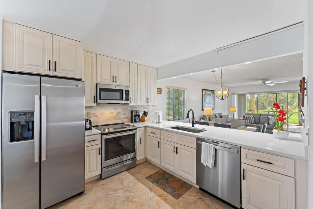 a kitchen with white cabinets and stainless steel appliances at Spacious 2BR 2BA apartment close to the beach in Jupiter