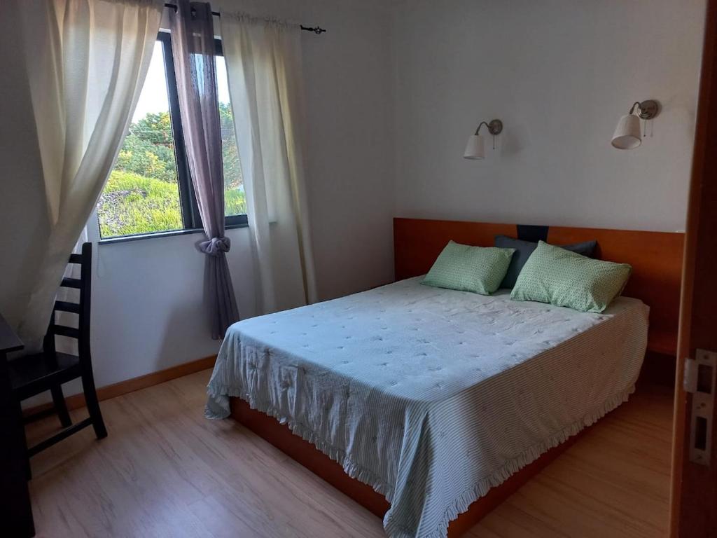 a bedroom with a bed and a window at Maroiço Residence in Madalena