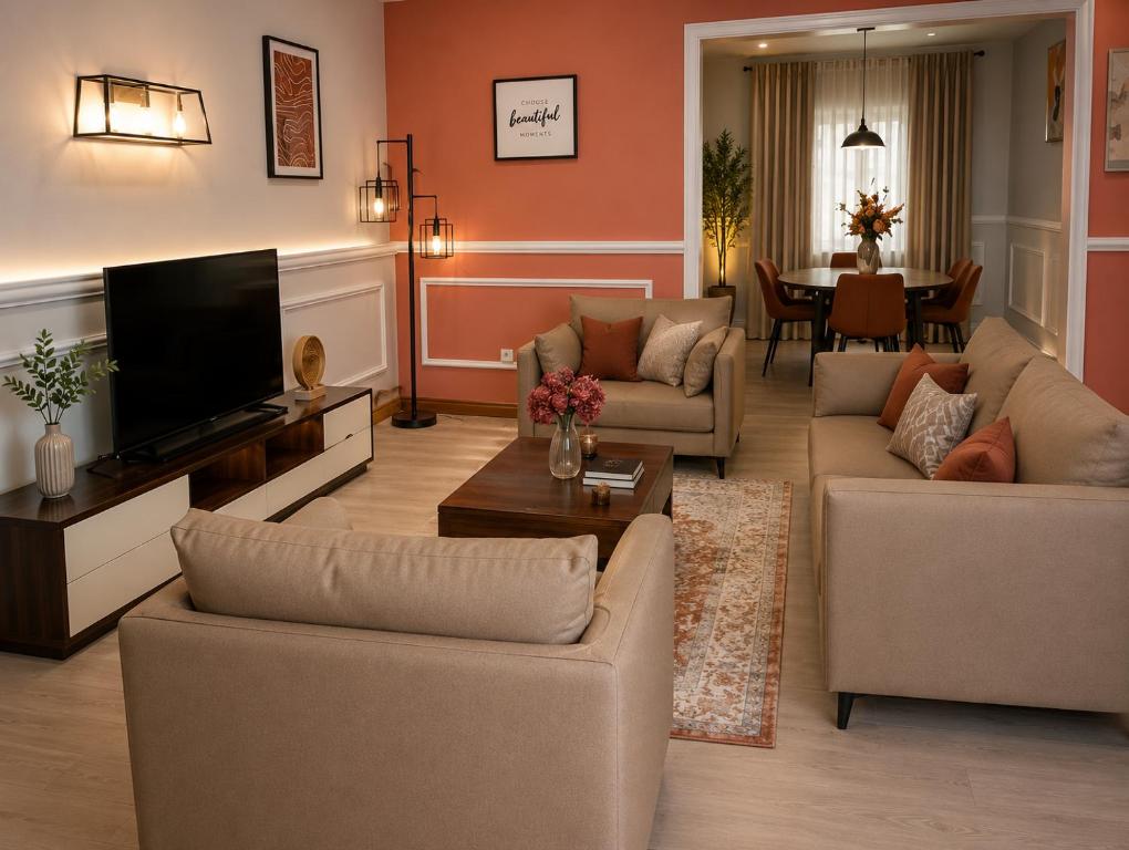 a living room with couches and a flat screen tv at The Blue Resort in Yaoundé