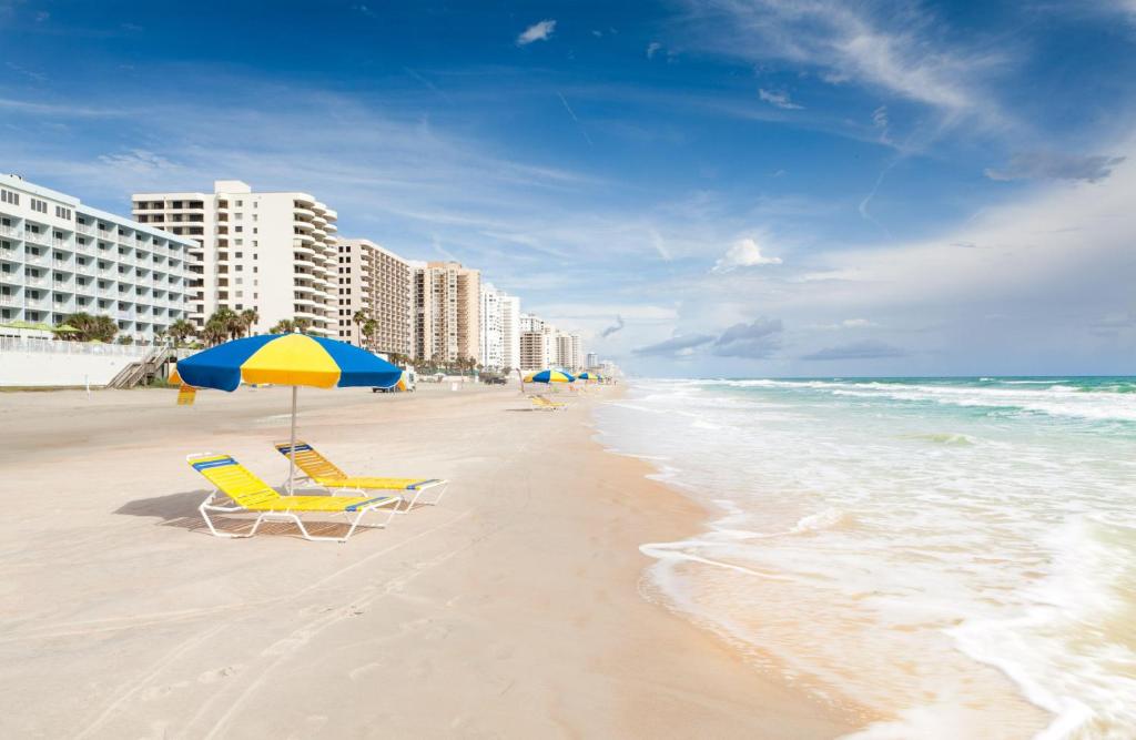 two chairs and an umbrella on a beach at Hilton Vacation Club Daytona Seabreeze Daytona Beach in Daytona Beach