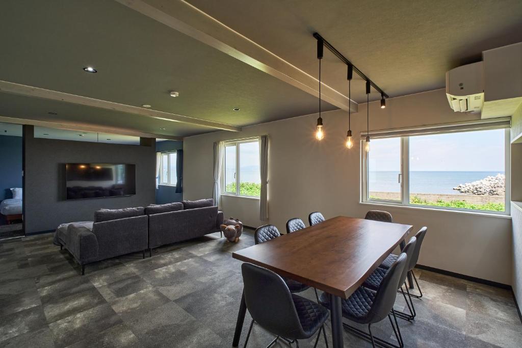 a dining room with a table and a couch at Aoyagi Stay in Shiomichō