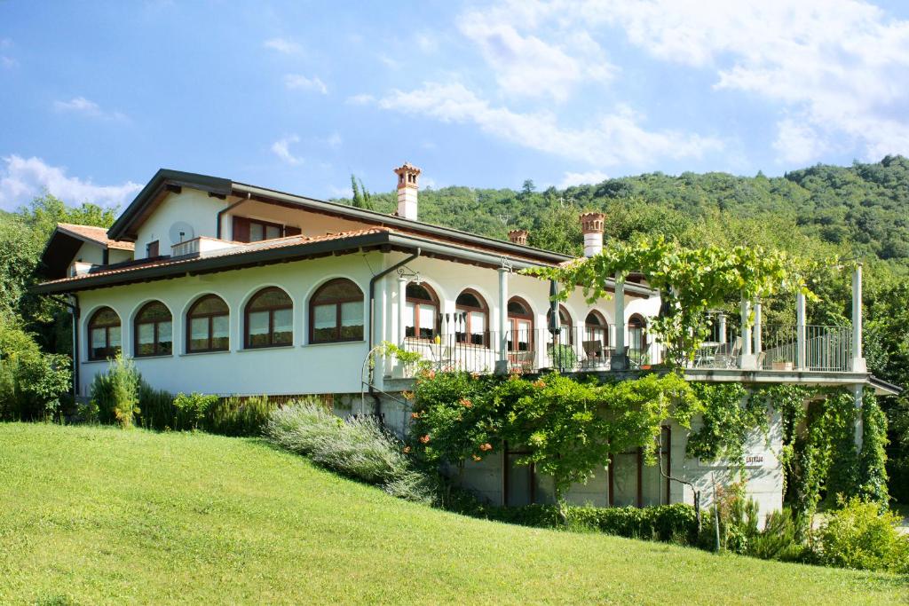 une grande maison sur une colline avec une cour verdoyante dans l'établissement Turistična kmetija Štanfel, à Podsabotin