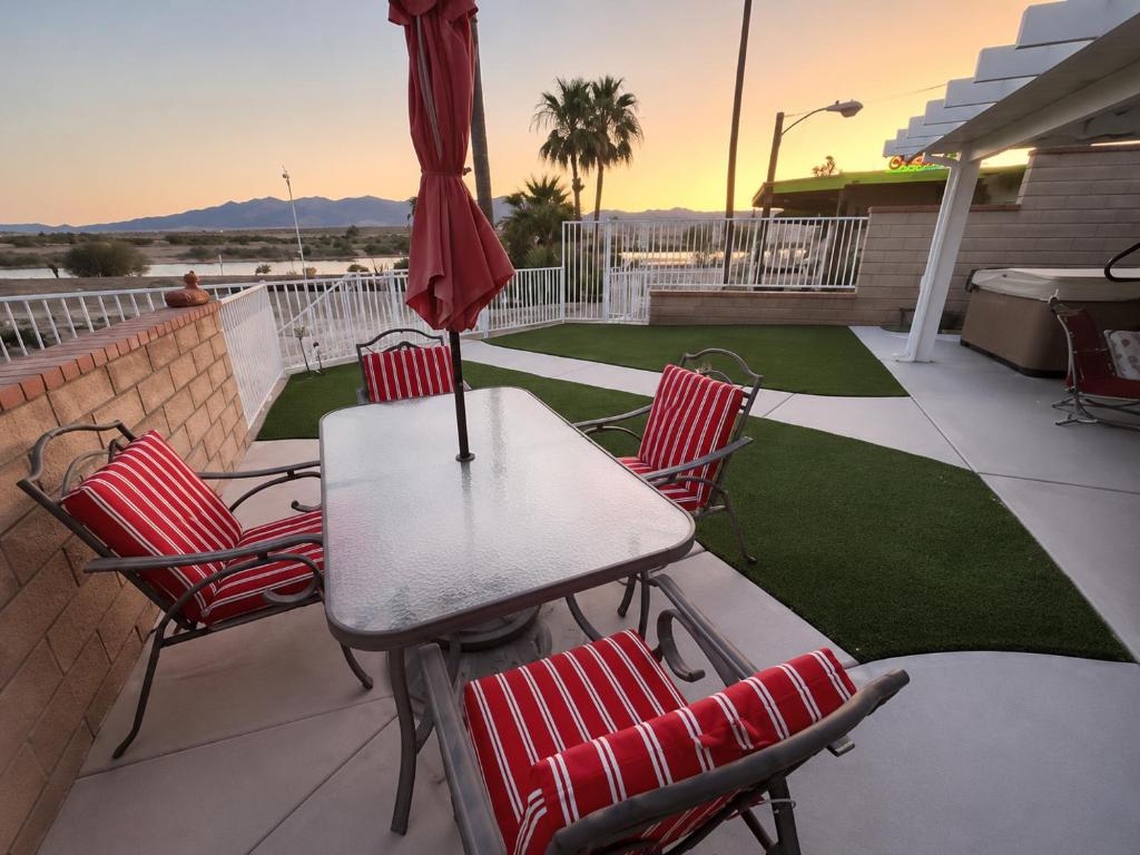a table and chairs with an umbrella on a patio at RIVERFRONT RUBY RED HOME WITH PRIVATE DOCK & View in Bullhead City