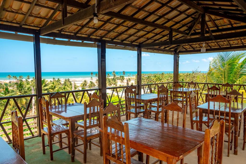 a restaurant with tables and chairs and the beach at Pousada Bela Vista in Conde