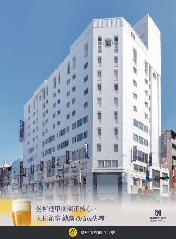 a white building with a cup of beer in front of it at Beacon Hotel in Taichung