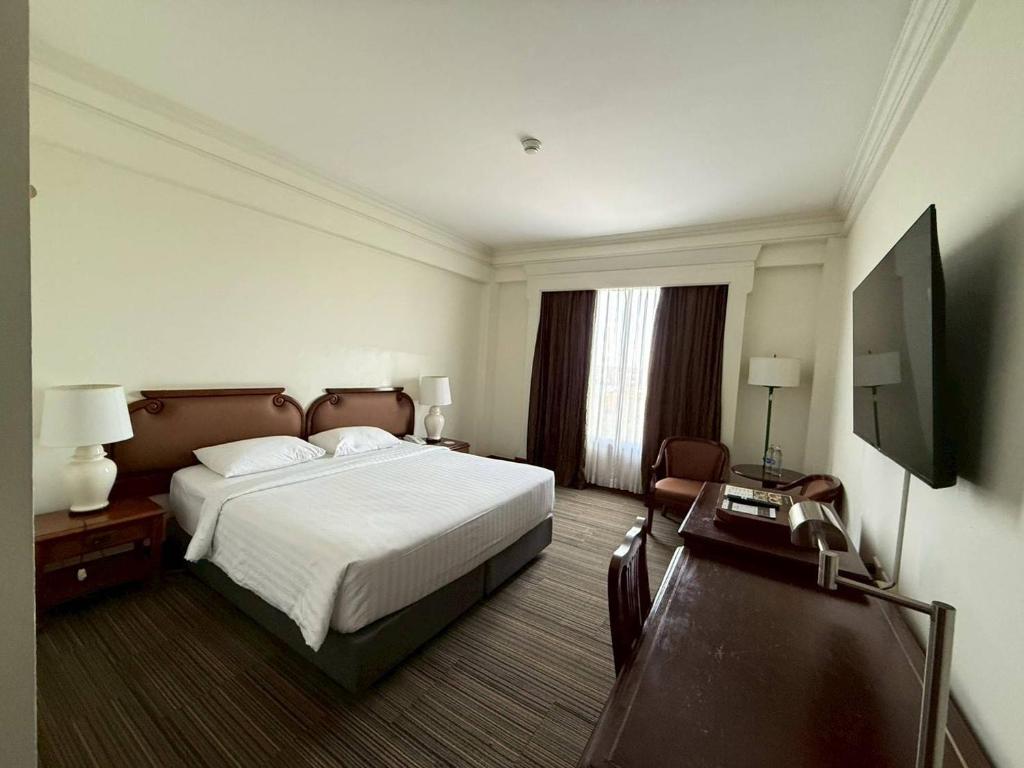 a hotel room with a bed and a flat screen tv at The Imperial Hotel & Convention Centre Korat in Nakhon Ratchasima