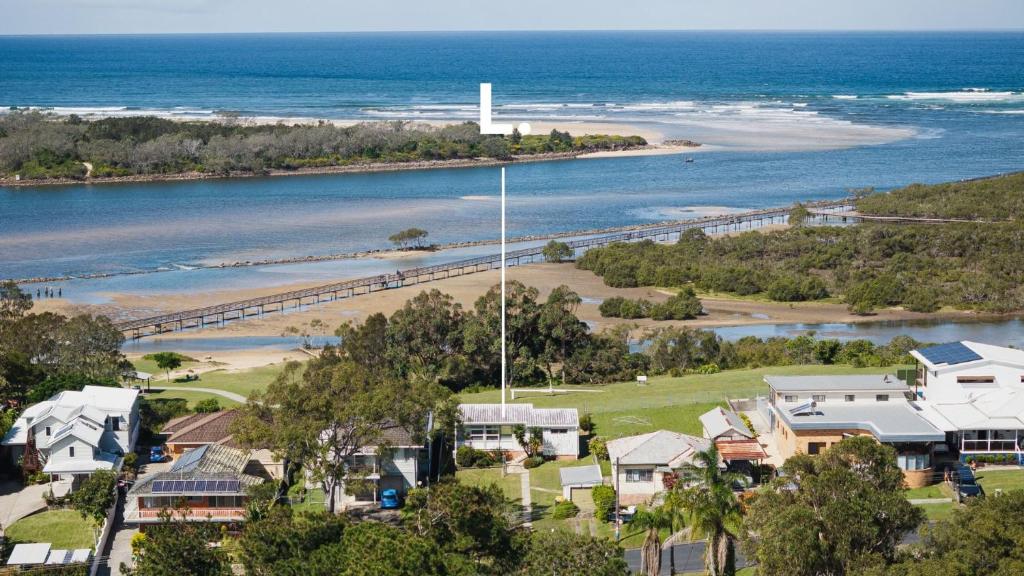 an aerial view of a beach with houses and the ocean at Boardwalk Bungalow - pristine ocean views in Urunga