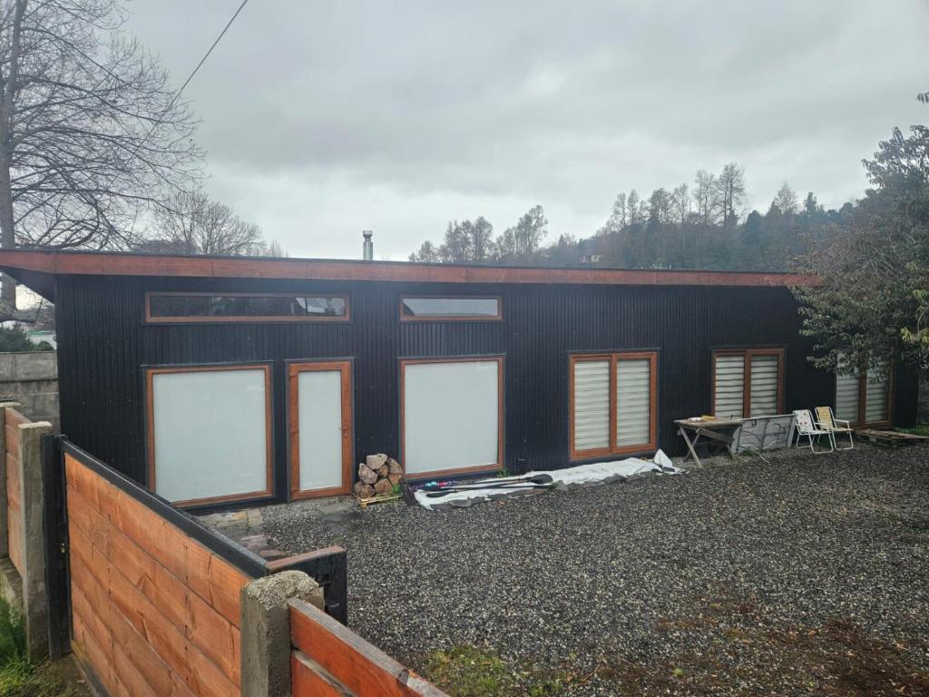 a black house with windows and a fence at Cabaña Lafken in Panguipulli