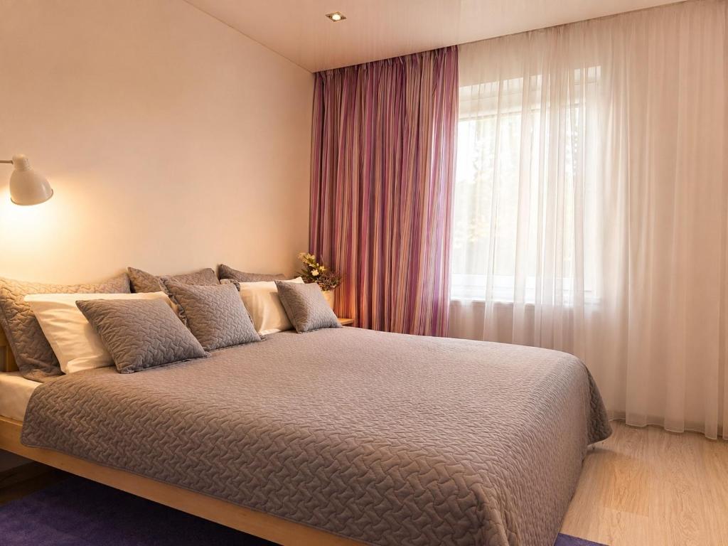 a bedroom with a large bed and a window at Mirdzas Ķempes iela 14 in Liepāja