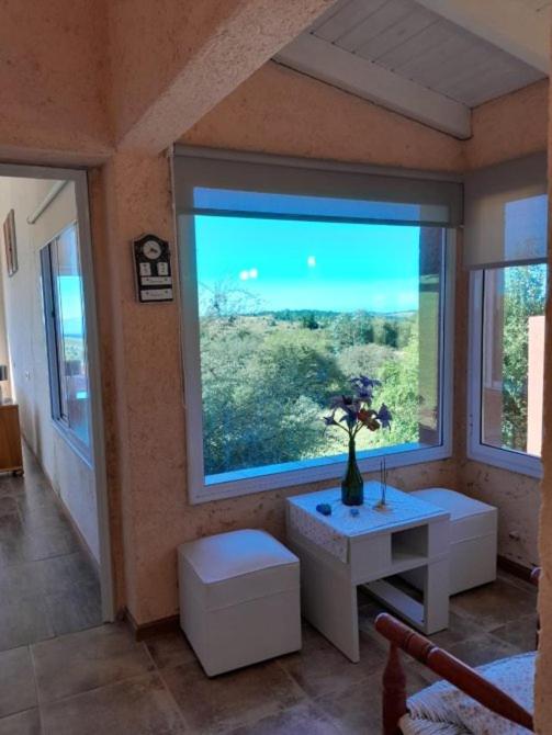 a room with a large window with a vase on a table at Iorana in Villa Berna