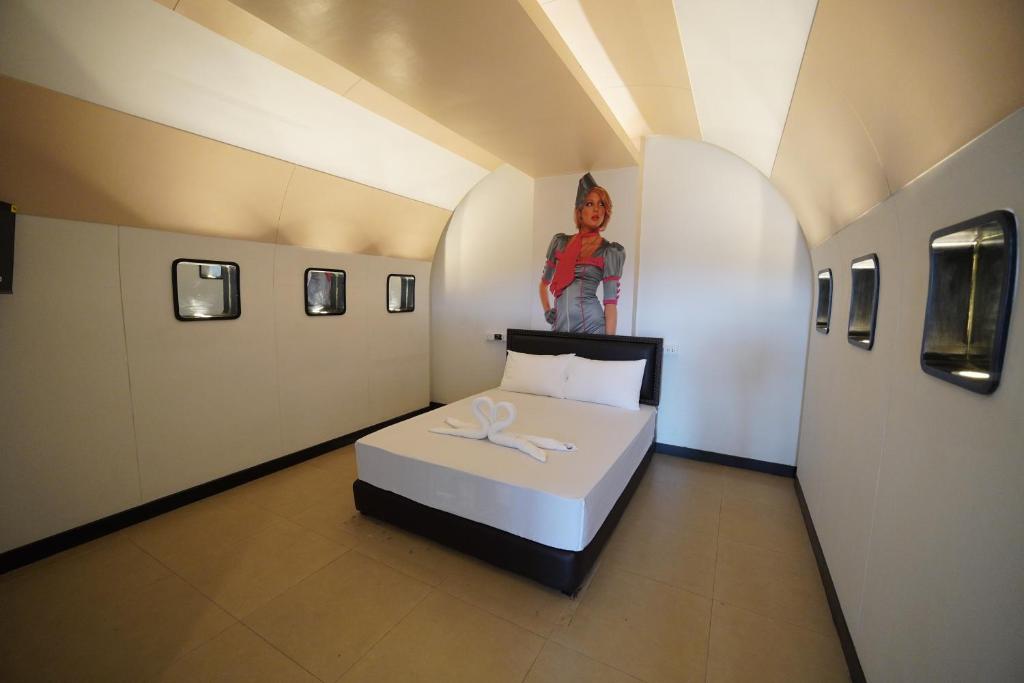 a room with a bed and a picture of a woman at โรงแรมทูมอร์โรว์แลนด์ อมตะนคร in Ban Khlong Phan Thong