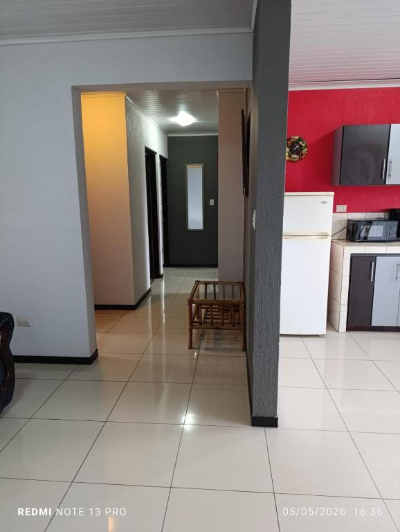 a hallway of a room with a kitchen and a table at Costa Rica explorer in Grecia