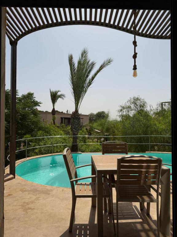 a patio with a table and chairs and a pool at Rose Garden Resort & Spa in Marrakesh