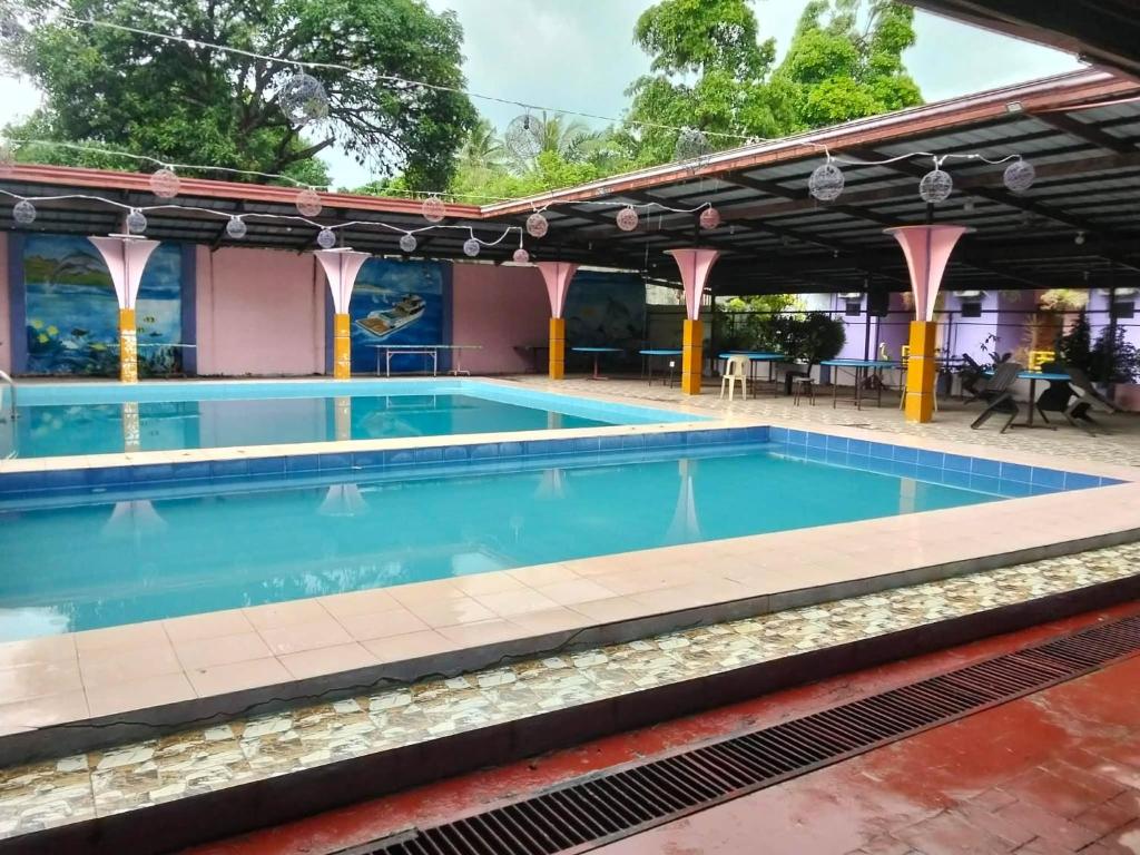 a large swimming pool with blue water at Janisah Pension House in Narra