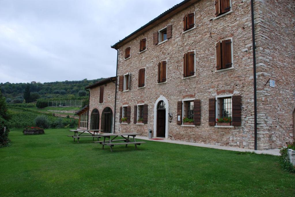 un edificio in mattoni con tavoli da picnic di fronte di Costa degli Ulivi a Fumane