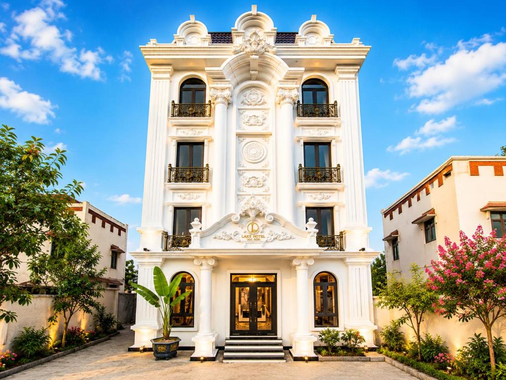 a white building with stairs in front of it at Lake Hotel Sóc Sơn in Sóc Sơn