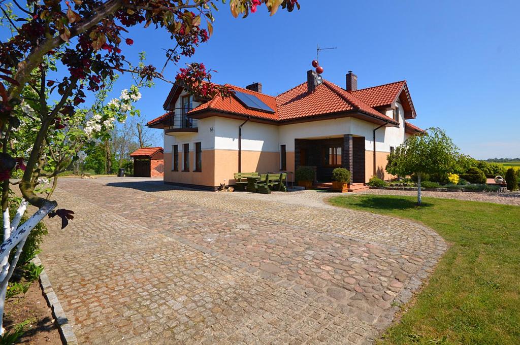 a house with a brick driveway in front of it at Villa Cis in Darłowo