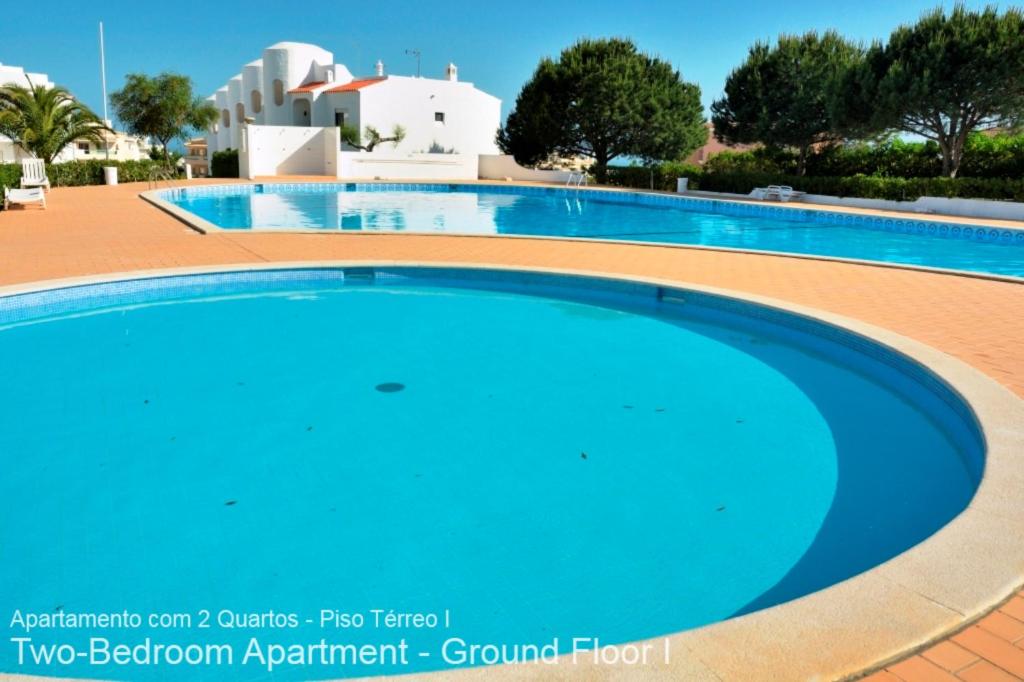 a large swimming pool in a resort with blue water at Akisol Armação Pera Relax in Armação de Pêra