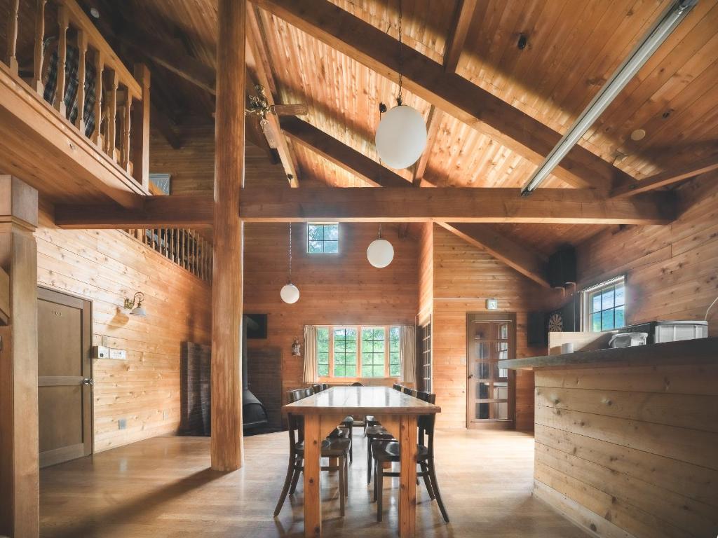 a dining room with wooden walls and a table at #65 Stella 八ヶ岳姫木平 in Tateshina