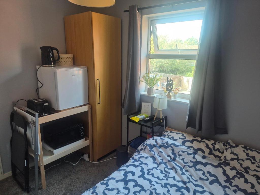 a bedroom with a bed and a dresser and a window at Clover Ground Home in Bristol