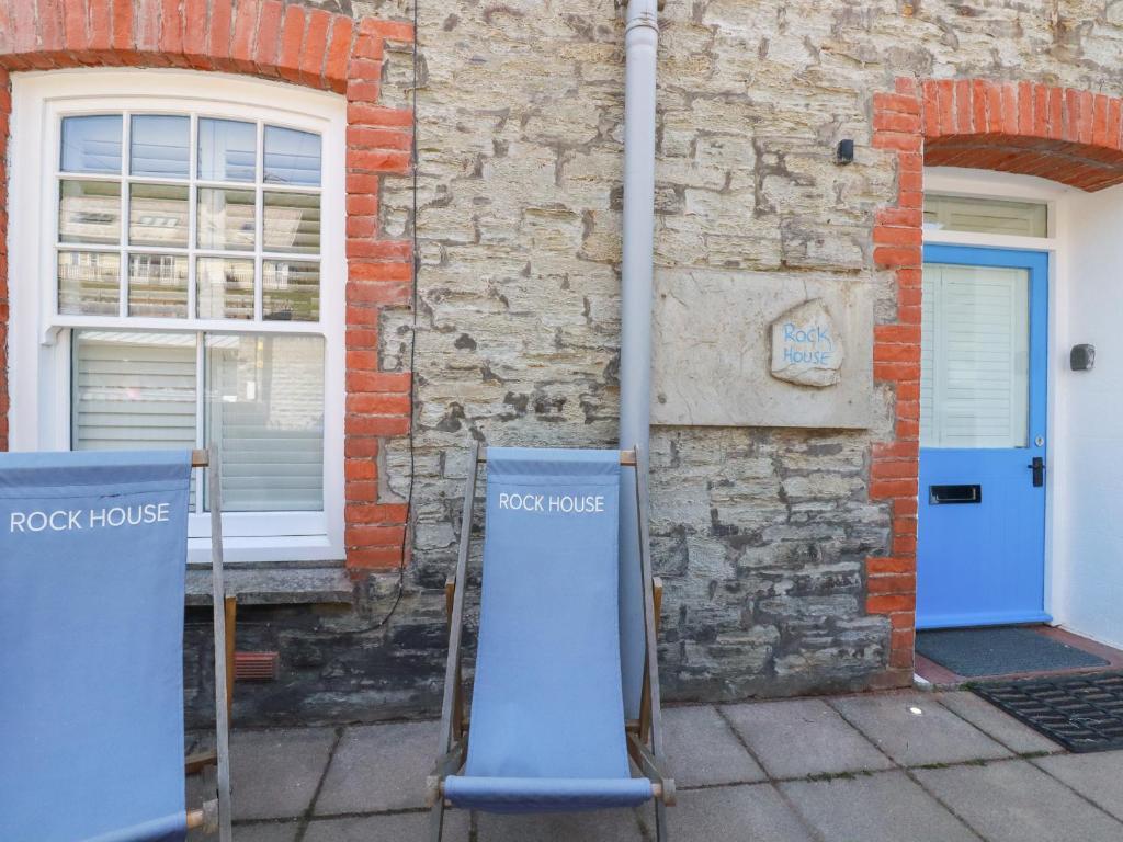a brick house with a blue door and a building at Rock House in Tintagel
