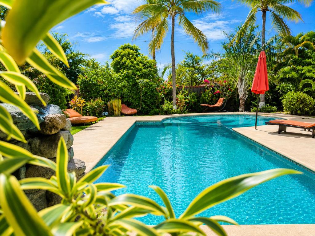 a swimming pool in front of a resort with palm trees at Casa Swell Coronado, Adults-Only Boutique Hotel, Pool & Beach in Playa Coronado