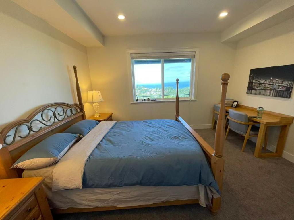a bedroom with a bed and a desk and a window at Sea view villa independent access in Nanaimo