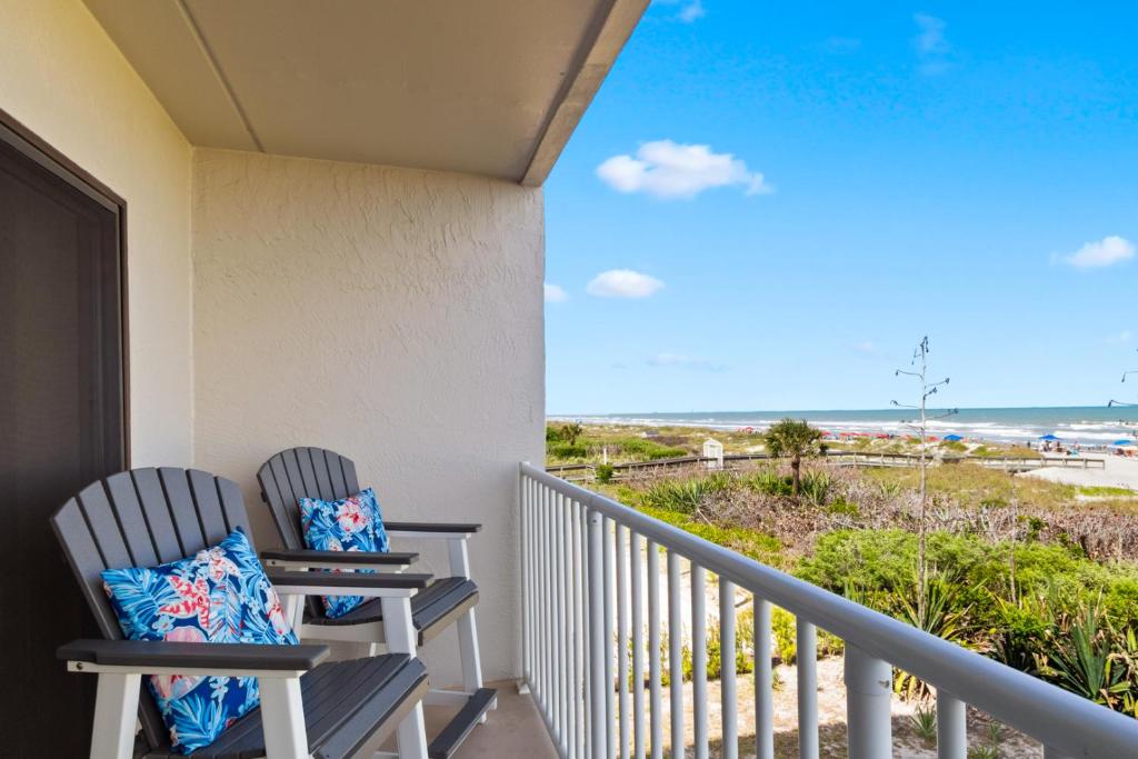 two chairs on a balcony with a view of the ocean at Boardwalk 201 in Cocoa Beach