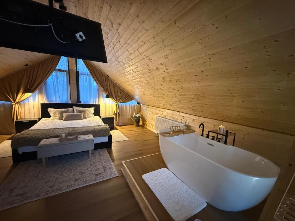 ein Badezimmer mit einem Bett und einer Badewanne in einem Zimmer in der Unterkunft Rose Romantic in Tărlungeni